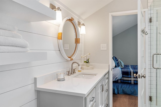 bathroom with a shower stall, wood finished floors, ensuite bathroom, vanity, and lofted ceiling