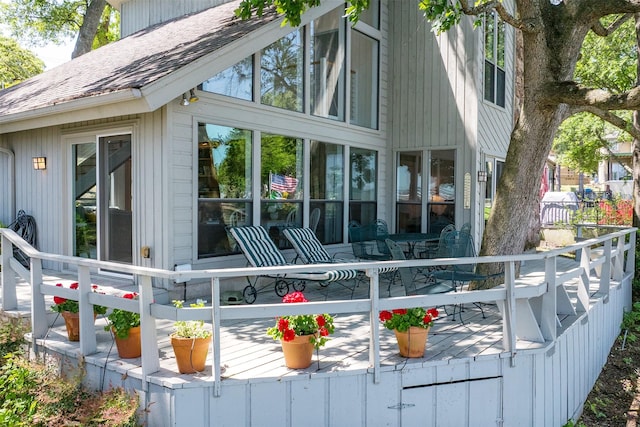 rear view of house featuring a shingled roof and a deck
