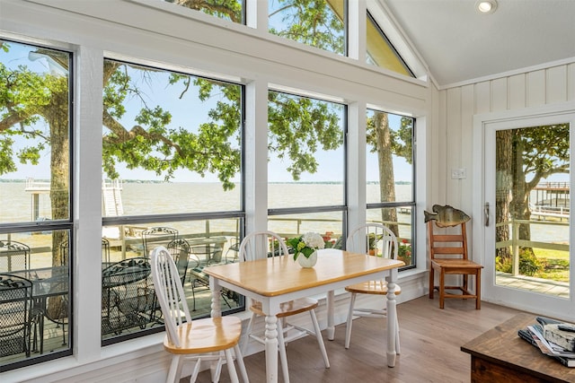 sunroom / solarium with vaulted ceiling, wood finished floors, recessed lighting, and a water view