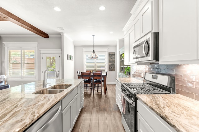 4114 Seminole Trl, Granbury, TX 76048 - kitchen featuring stainless steel appliances, a sink, wood finished floors, light stone countertops, and recessed lighting