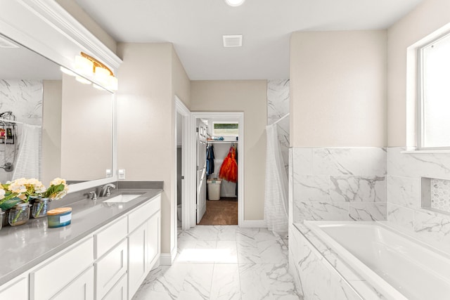 4114 Seminole Trl, Granbury, TX 76048 - bathroom with marble look tile flooring, a walk in closet, vanity, and a bath