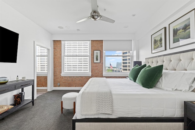 carpeted bedroom with brick wall, baseboards, and a ceiling fan