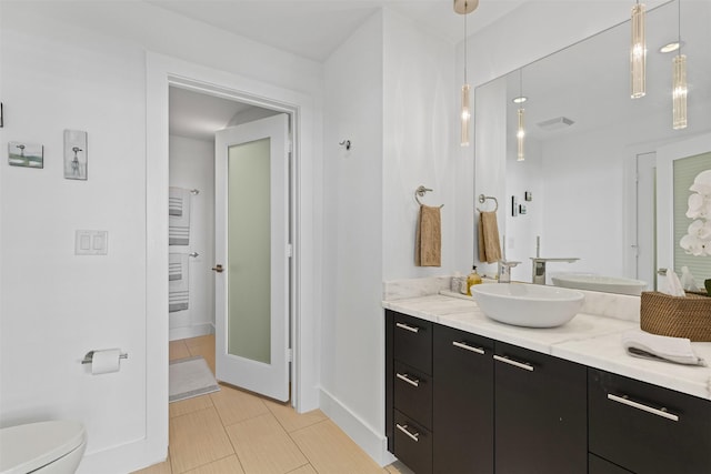 bathroom featuring baseboards, visible vents, toilet, and vanity