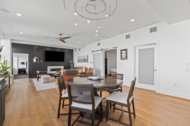dining area featuring a barn door, a ceiling fan, visible vents, and recessed lighting