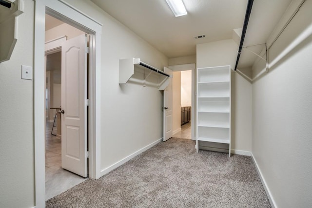 spacious closet featuring visible vents and light colored carpet