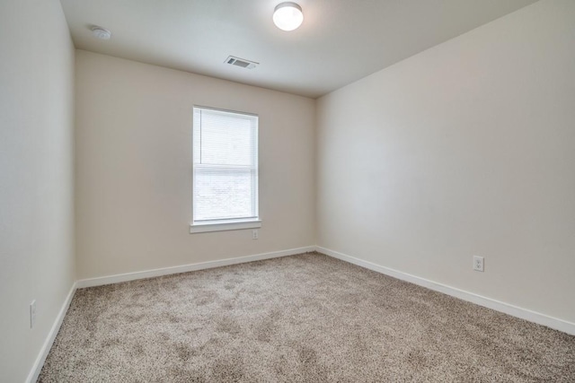 spare room featuring visible vents, baseboards, and carpet floors