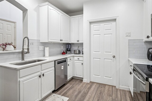 kitchen with backsplash, dishwasher, white cabinetry, and a sink