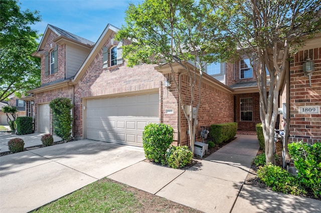 traditional home with brick siding, an attached garage, a shingled roof, and concrete driveway