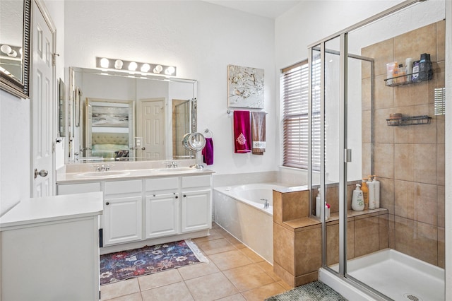 bathroom with a bath, tile patterned floors, a stall shower, and a sink