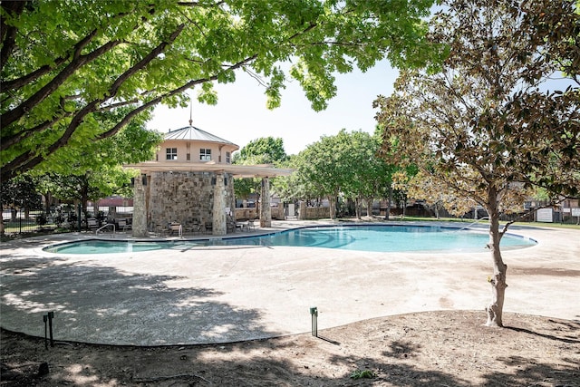 community pool featuring fence and a patio