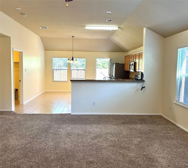 interior space featuring vaulted ceiling, baseboards, an inviting chandelier, light colored carpet, and light tile patterned floors