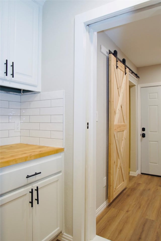 416 Rolling Hills Dr, Aledo, TX 76008 - kitchen featuring butcher block countertops, a barn door, backsplash, light wood-type flooring, and baseboards