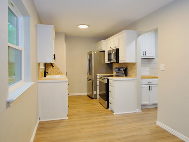 416 Rolling Hills Dr, Aledo, TX 76008 - kitchen featuring appliances with stainless steel finishes, a sink, decorative backsplash, light wood-style flooring, and light countertops