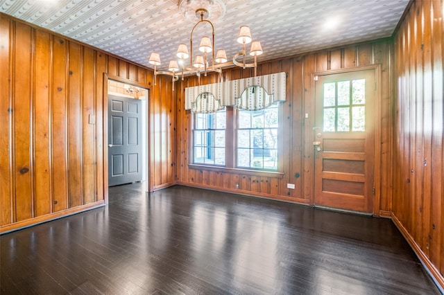 5015 Stoneleigh Ave, Dallas, TX 75235 - unfurnished dining area featuring wooden walls, wood finished floors, baseboards, and a notable chandelier