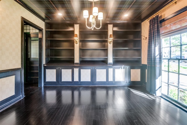 5015 Stoneleigh Ave, Dallas, TX 75235 - unfurnished living room featuring a wainscoted wall, dark wood-type flooring, a decorative wall, built in shelves, and a notable chandelier