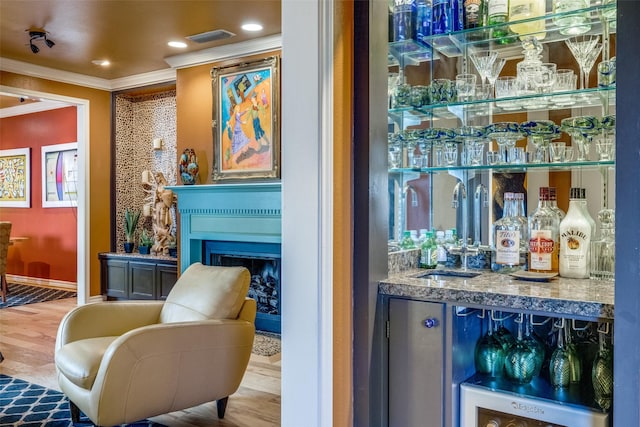 5713 Pershing Ave, Fort Worth, TX 76107 - bar featuring a sink, visible vents, a bar, wood finished floors, and crown molding