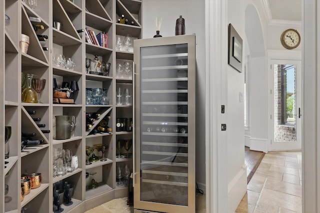 walk in closet featuring wine cooler and stone tile flooring