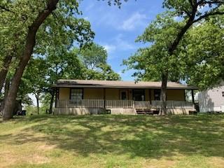 rear view of property featuring a lawn and covered porch