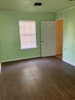 empty room with baseboards and dark wood-style floors