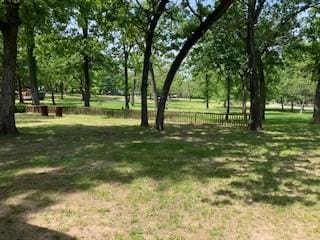 view of home's community with fence and a lawn