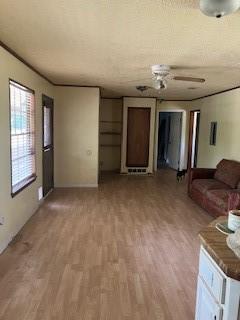 living area featuring light wood-type flooring and a ceiling fan