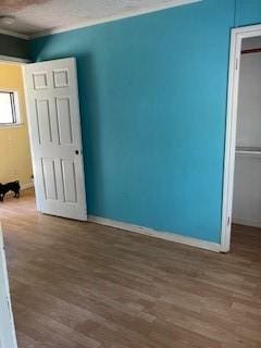 spare room with baseboards and wood finished floors
