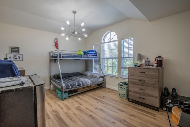 bedroom featuring light wood-type flooring, baseboards, a notable chandelier, and lofted ceiling
