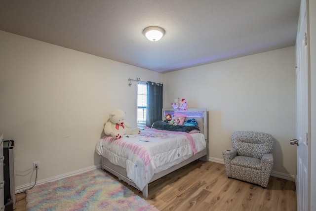 bedroom with baseboards and wood finished floors