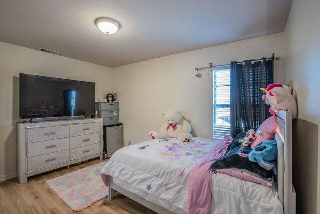 bedroom featuring light wood-type flooring, baseboards, and visible vents
