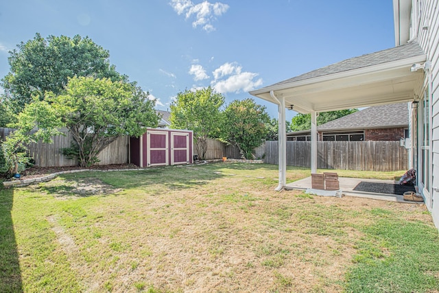 view of yard with a fenced backyard, an outbuilding, and a storage shed