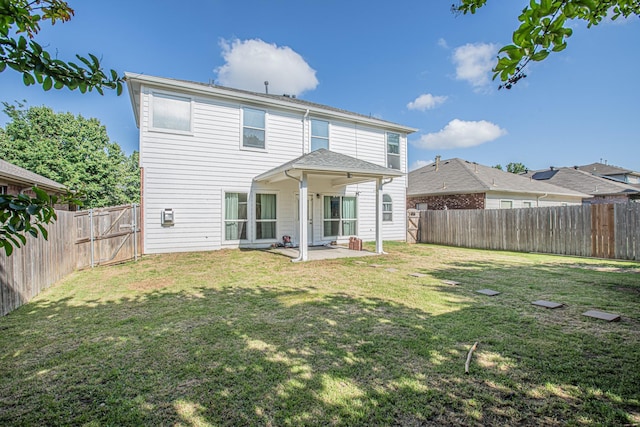back of house featuring a fenced backyard, a yard, and a patio