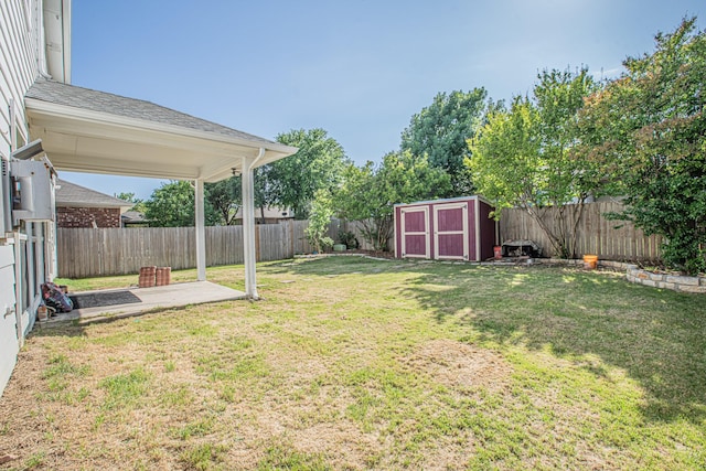 view of yard with a fenced backyard, an outbuilding, a patio, and a storage unit