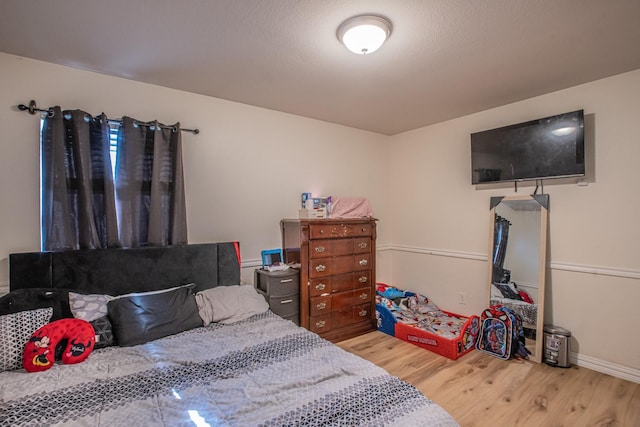 bedroom with baseboards and wood finished floors