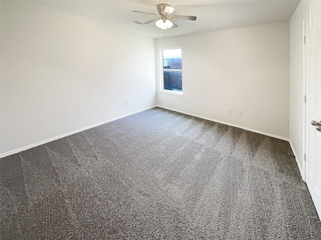 spare room featuring dark carpet, visible vents, baseboards, and ceiling fan