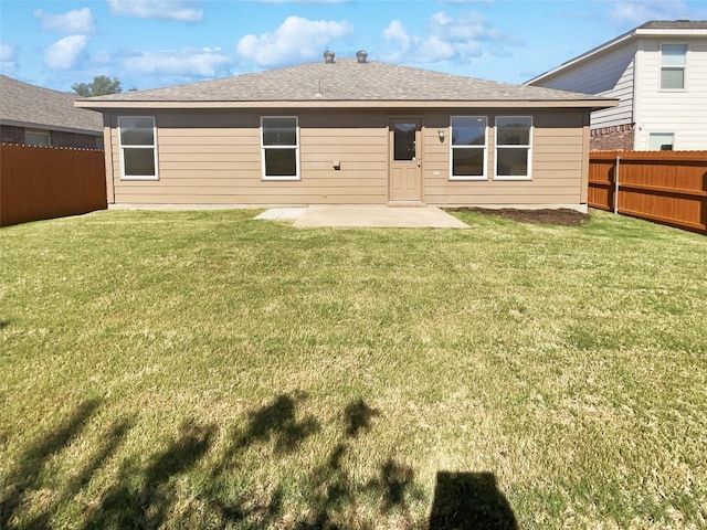 back of house with a lawn, a fenced backyard, roof with shingles, and a patio