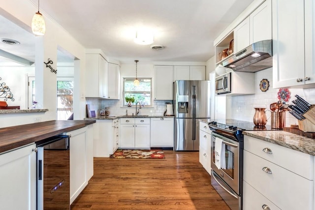 717 Cliffside Dr, Richardson, TX 75080 - kitchen with appliances with stainless steel finishes, beverage cooler, under cabinet range hood, butcher block countertops, and a sink