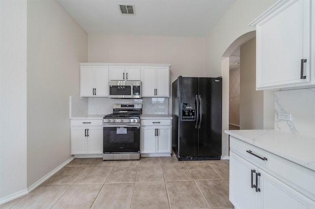 kitchen with stainless steel appliances, visible vents, arched walkways, decorative backsplash, and white cabinetry