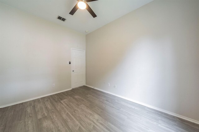 empty room with high vaulted ceiling, wood finished floors, ceiling fan, baseboards, and visible vents
