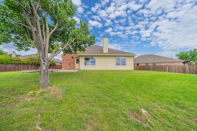 back of house featuring a lawn and a fenced backyard