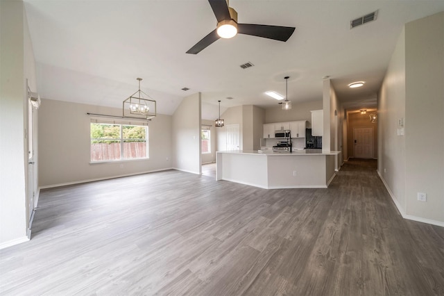 unfurnished living room featuring vaulted ceiling, baseboards, wood finished floors, and visible vents