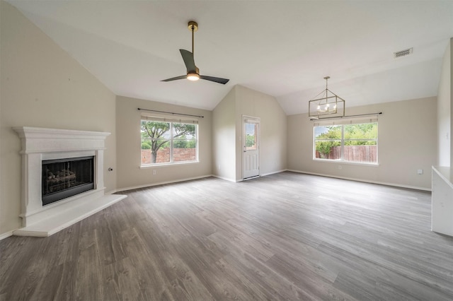 unfurnished living room featuring vaulted ceiling, baseboards, visible vents, ceiling fan with notable chandelier, and wood finished floors