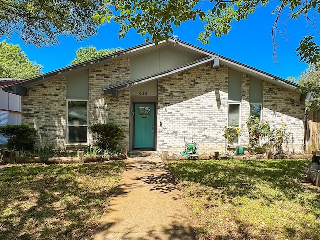 view of front of home featuring brick siding and a front yard