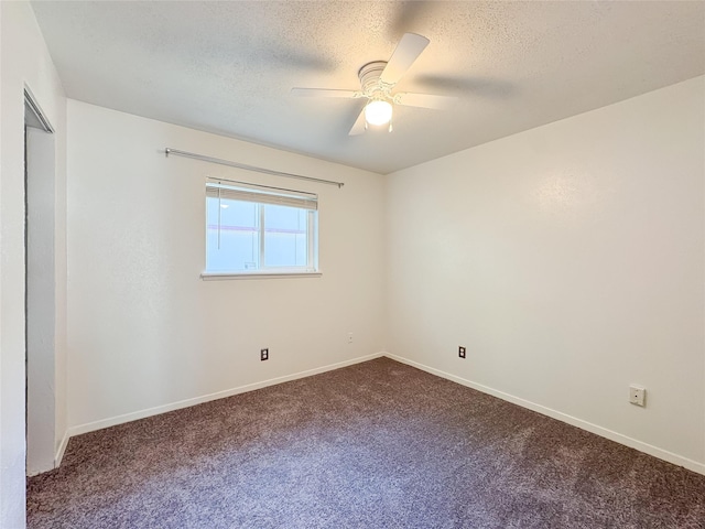 unfurnished room featuring dark carpet, a textured ceiling, a ceiling fan, and baseboards