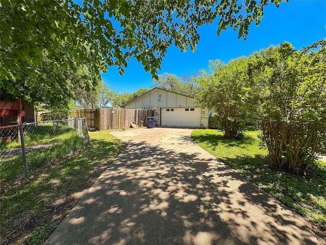 view of side of home featuring concrete driveway, fence, and board and batten siding