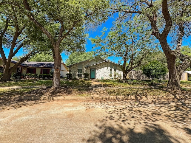 view of front of house featuring brick siding and fence