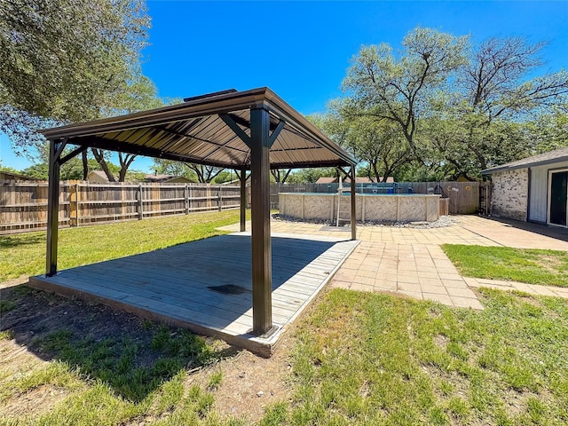 view of yard with a fenced backyard, a wooden deck, a gazebo, and a fenced in pool