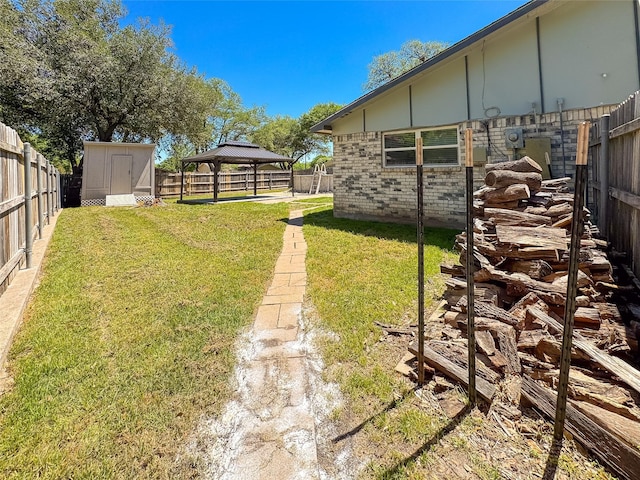 view of yard featuring a storage shed, a fenced backyard, an outdoor structure, and a gazebo