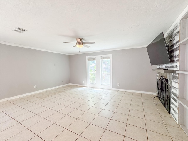 unfurnished living room featuring a textured ceiling, baseboards, a fireplace with raised hearth, ceiling fan, and crown molding