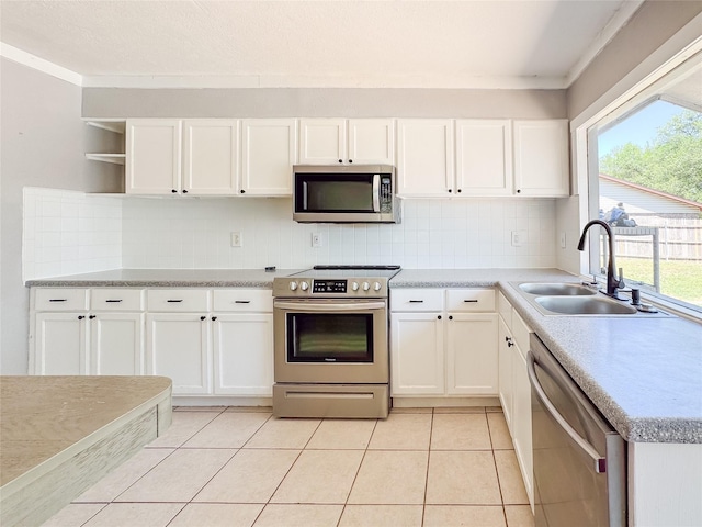 kitchen with open shelves, a sink, decorative backsplash, white cabinetry, and appliances with stainless steel finishes