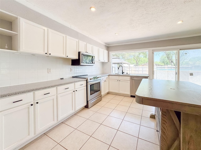 kitchen with open shelves, a textured ceiling, decorative backsplash, white cabinets, and appliances with stainless steel finishes